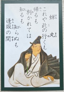 A picture of a karuta card depicting Semimaru (poem 10), with his poem above his head. His clothes look similar to a monk and he is holding a Buddhist rosary. His eyes are closed, as he was reputedly blind.